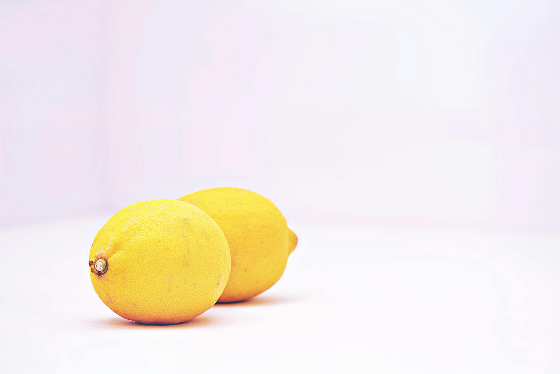 A yellow silicone clitoral vibrator surrounded by peeled bananas on a bright yellow background