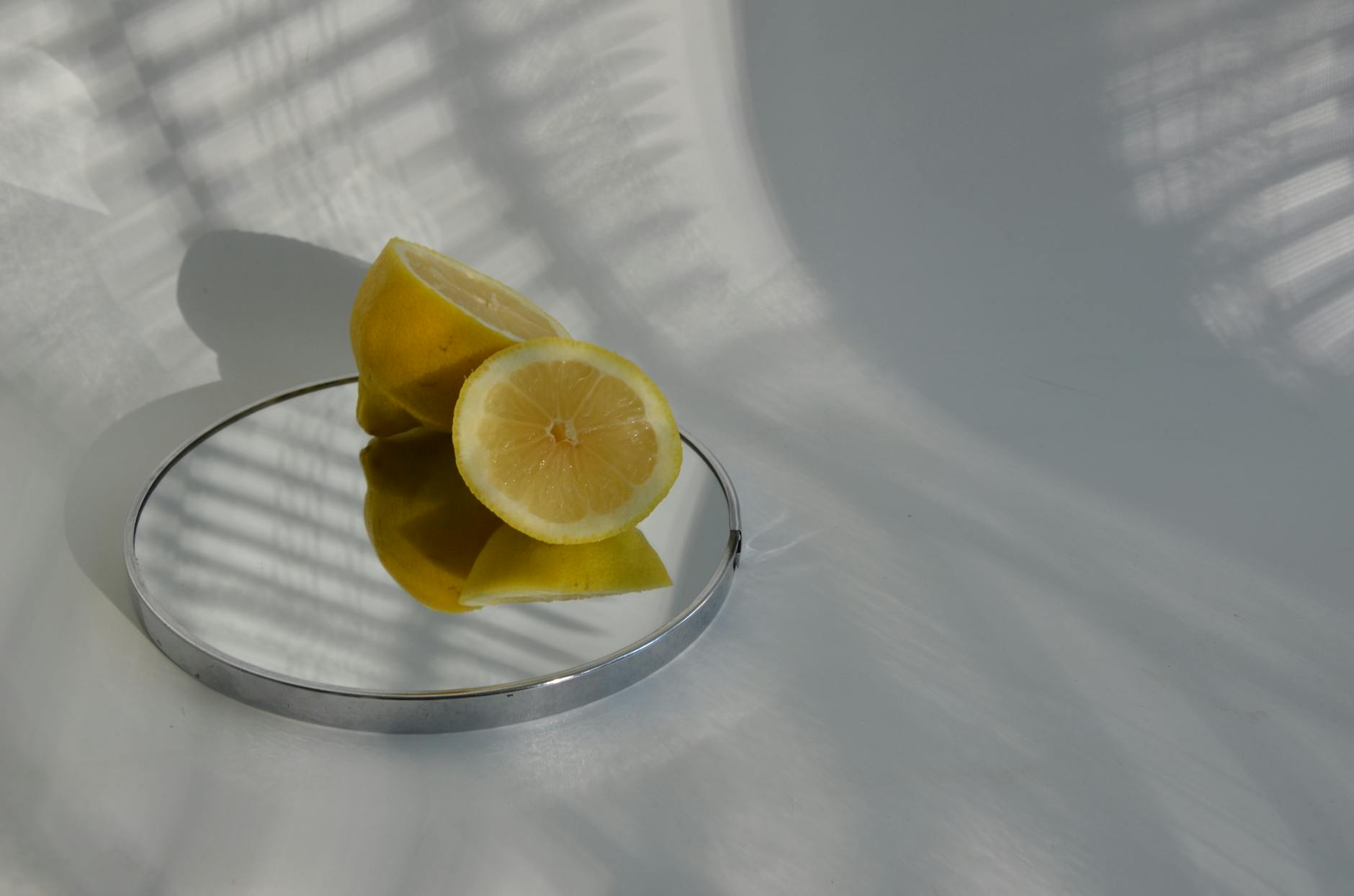 Limones cortados en espejo con sombras, fotografía minimalista de alimentos