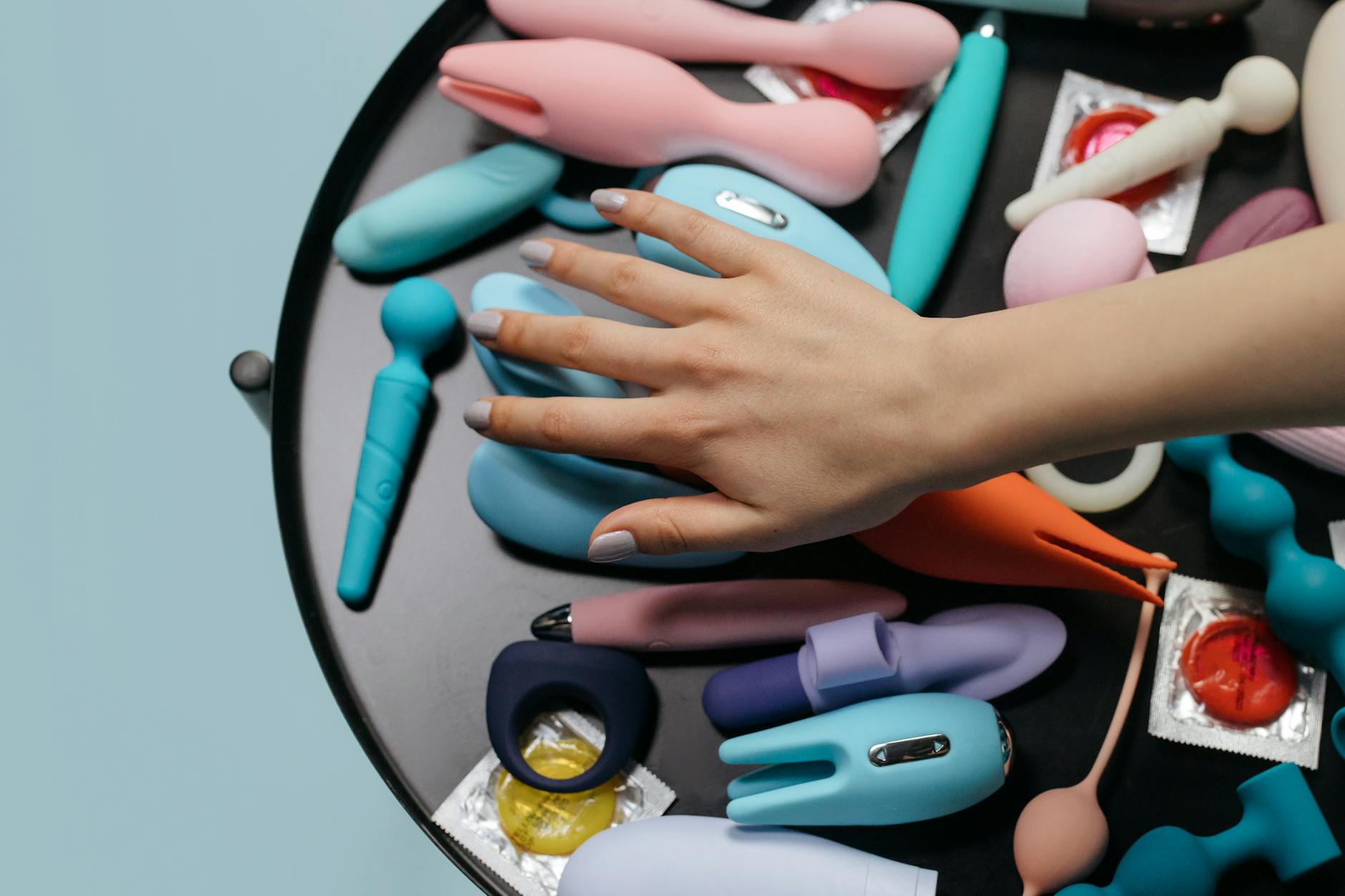 Woman holding colorful silicone vibrators, exploring different clitoral stimulation options