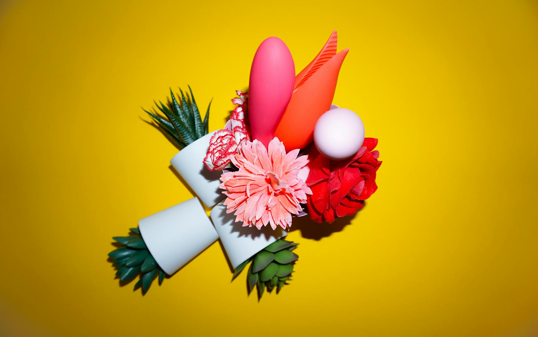 Vibrant collection of clitoral vibrators and toys displayed on a bright yellow surface