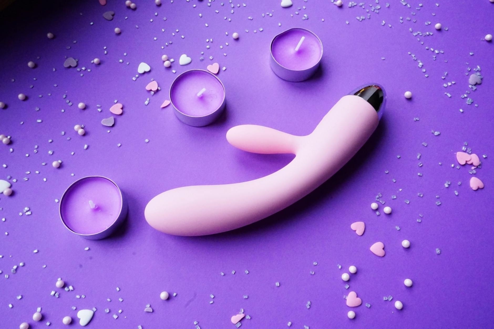 A couple standing close together, holding a blue vibrator, representing modern shared intimacy in partnerships